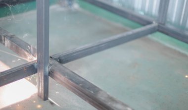 İşçi, fabrikada Meşale ve Koruyucu Miğfer ile kaynak yapıyor..