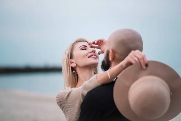 Et lykkelig par morer seg på stranda, holder hverandre i hånden . – stockfoto