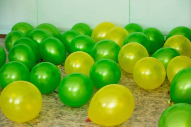 İki renk yeşil ve sarı balonlar yerde yatıyor.