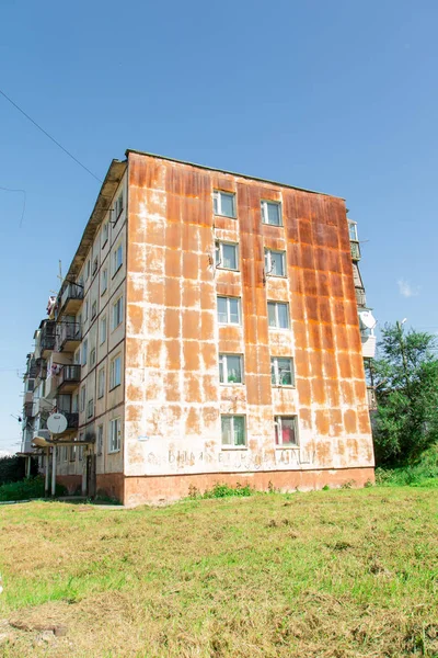 Stěna pětipodlažní obytné budovy se systémem Windows, pokrytá rzi. Okna směřující do ulice. — Stock fotografie