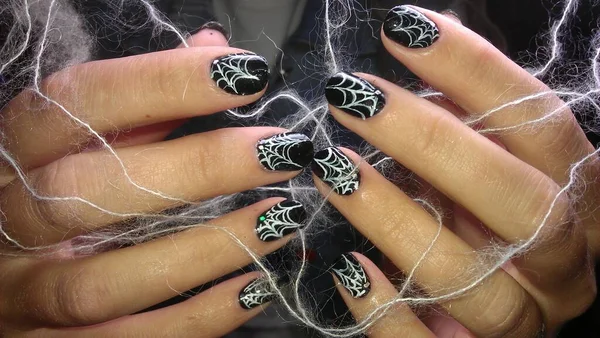 Halloween-Maniküre. Hexenhände in einem Netz, in der Hand eine brennende Kerze. Halloween-Konzept, schwarze Kunst. — Stockfoto