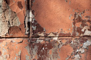 Üç parçaya bölünmüş eski, çatlak, pul pul pembe bir duvar..