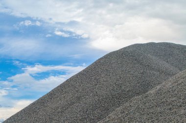 Büyük bir moloz dağı, bulutlu mavi gökyüzüne karşı..