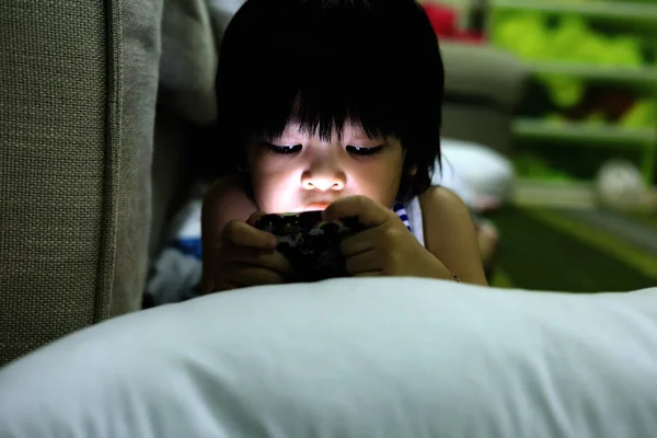 Smartphone üzerinde oyunlar oynayan sevimli Asya çocuk