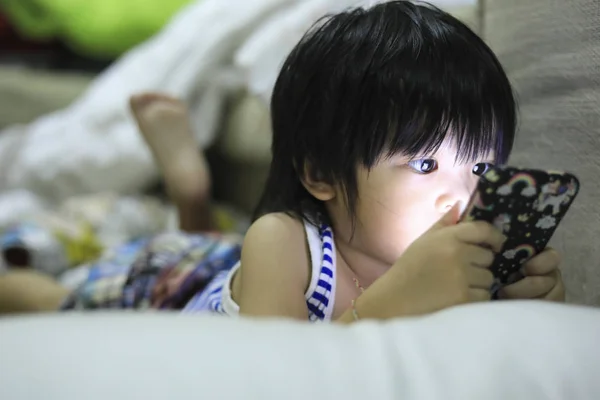 Süße Asiatische Kind Spielen Spiele Auf Dem Smartphone Stockbild