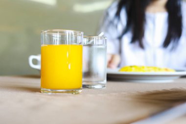 Kahvaltı masasında su ve portakal suyu bir bardak