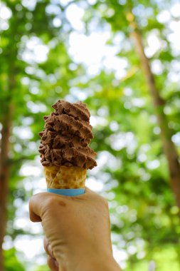 yeşil ağaç arka plan ile el dondurma