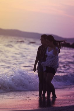 Mutlu kız sahilde günbatımı sırasında yürüyüş 