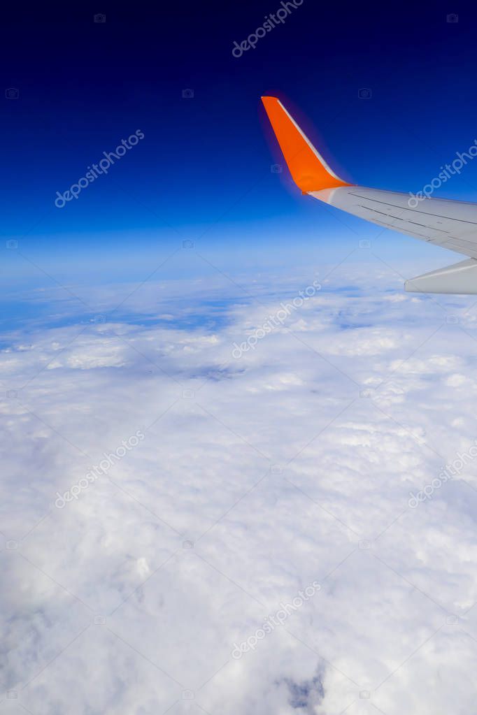 airplane wing over the blue cloud sky