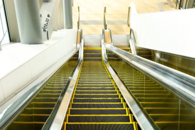 Tren İstasyonu, alışveriş merkezi veya mağaza içinde yürüyen merdiven. Hareketli merdiven. Neon ışık, Modern yürüyen merdiven