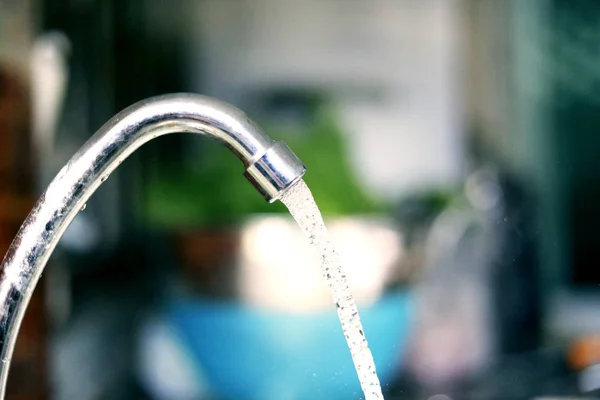 water flows from a pipe or water gushing out of the pipe close up