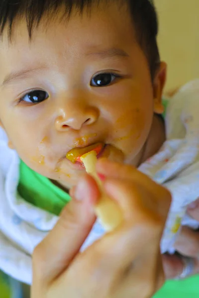 happy eating : little asian boy enjoys eating food