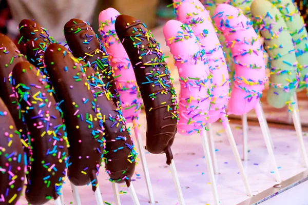 Bananas covered with dark chocolate with rainbow sprinkles Selective focus