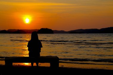 Alone concept :Alone girl sitting near the sea