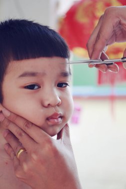 Yüz değiştirme: küçük Asya çocuk saç kesimi Kuaför tarafından oluyor