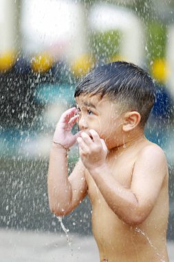 Kid boy playing with water during take shower.