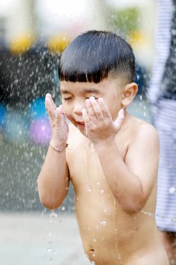 Kid boy playing with water during take shower.