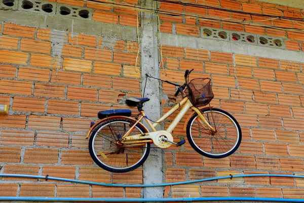 Bicicleta velha pendurar na parede de tijolo — Fotografia de Stock