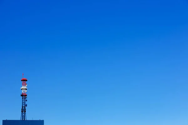 Torre de comunicación en el edificio con el cielo azul en el fondo . — Foto de Stock