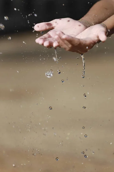 Water Pouring in Child 's Hands — стоковое фото