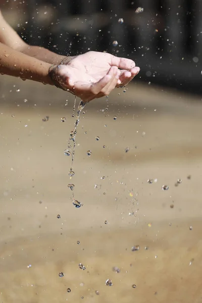 Water Pouring in Child 's Hands — стоковое фото