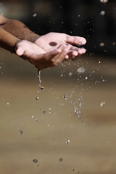 Vatten hälla i barnets händer — Stockfoto
