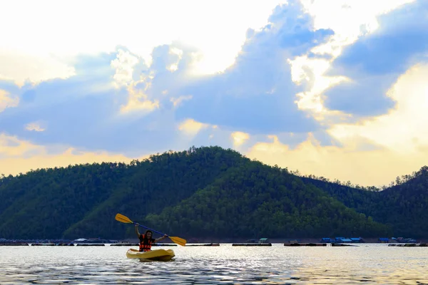 Kayak sul lago e tramonto dietro il backgroun di montagna — Foto Stock
