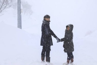 kar üzerinde el ele yürüyen çift sevgilisi, Gala Yuzawa/ Japonya