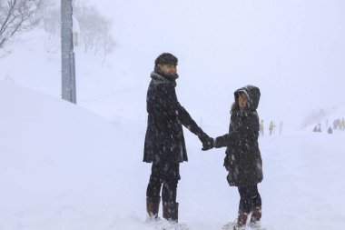 kar üzerinde el ele yürüyen çift sevgilisi, Gala Yuzawa/ Japonya
