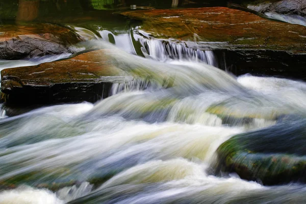 Het water stroomt door de rotsen in de stroom. — Stockfoto