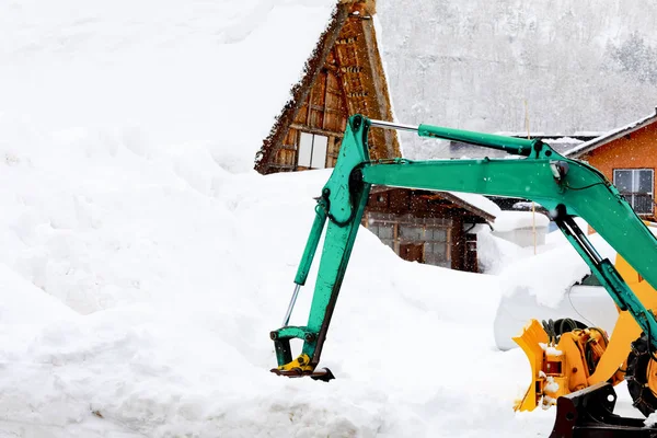 excavator take out snow in the heavy snow falling day