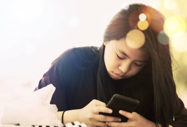 Akıllı telefon ile oynayan genç asyalı kız