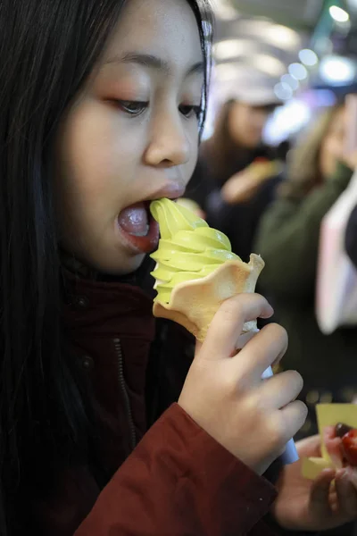 Green tea flavored ice cream on young girl hand,japanese street