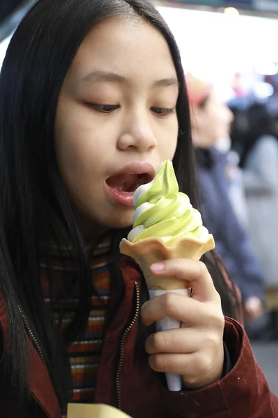 Green tea flavored ice cream on young girl hand,japanese street