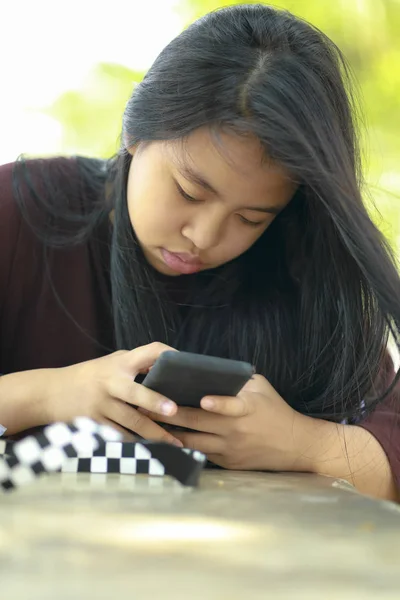 Девушка-подросток, играющая со смартфоном — стоковое фото