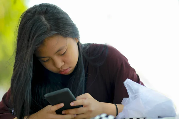 Teenage asian girl playing with smartphone — Stock Photo, Image
