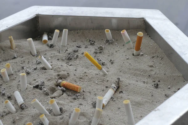 Cigarette butt cigarette on Ashtray with sand and cigarette stub — Stock Photo, Image