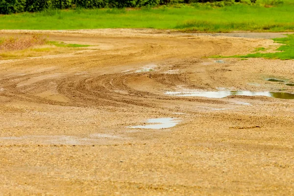 Water trapped in the hole cause of car wheels on the dirt road in the rainy season.