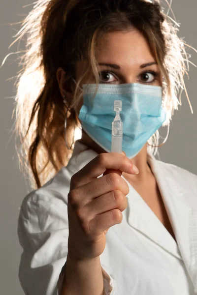 灰色の背景に哲学を示す医療制服を着た女性のクローズアップ 哲学に焦点を当てる — ストック写真