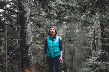 Genç bir kadın dağlarda her daim yeşil bir ormanda yürüyüş yapıyor, açık havada aktif bir gün geçiriyor, doğada dinleniyor. 