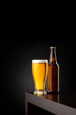 Bir bardak soğuk soluk bira ve bir bira şişesi fotokopi yeri olan bir bar tezgahına konmuş.