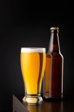 Bir bardak soğuk soluk bira ve bir bira şişesi tezgahın üzerine konmuş.