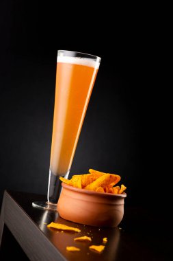 Bir bardak soğuk greyfurt birası ve tezgahta bir kase tortilla cipsi.