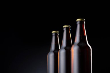 Arka arkaya üç şişe soğuk bira, fotokopi alanı olan bir bar tezgahında.