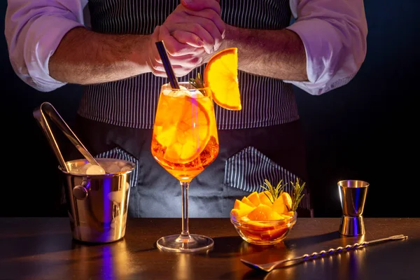 バーテンダー Aperol Spritz カクテル バーカウンターのワイングラスでオレンジリキュールカクテルを提供するバーマン — ストック写真