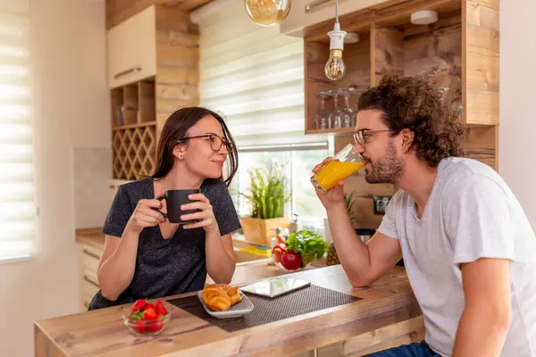 Couple in love relaxing at home in the morning, drinking coffee and having breakfast