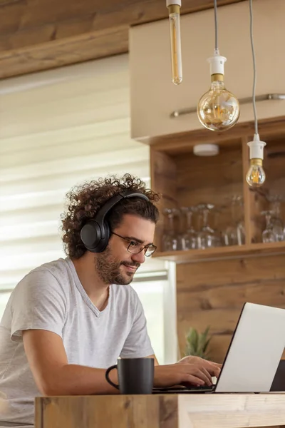 Freelancer Masculino Sentado Mostrador Cocina Usando Auricular Ordenador Portátil Trabajando —  Fotos de Stock