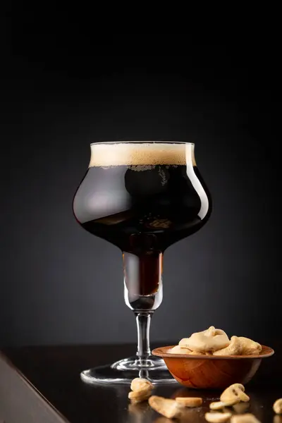 Ein Glas Kaltes Dunkles Bier Und Eine Schale Cashewkerne Auf — Stockfoto