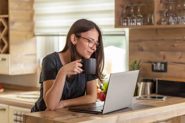 Vrouw Zit Aan Aanrecht Drinkt Koffie Leest Nieuws Met Behulp — Stockfoto