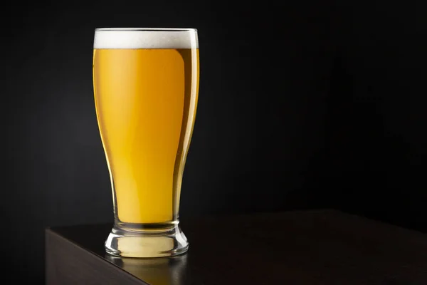 放在带有复制空间的酒吧柜台上的啤酒玻璃杯中的冷淡啤酒 — 图库照片